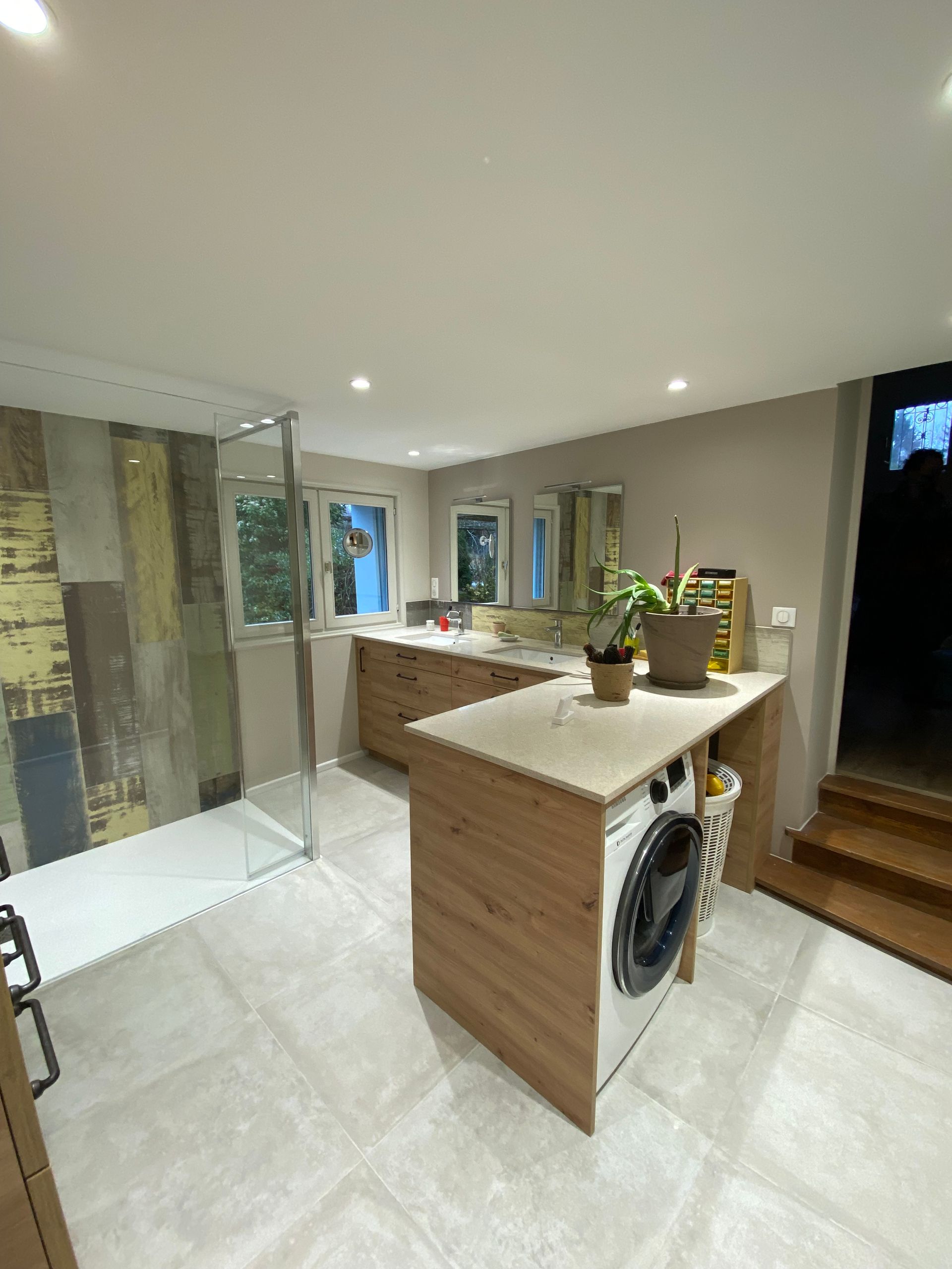 Une salle de bains rénovée avec une machine à laver