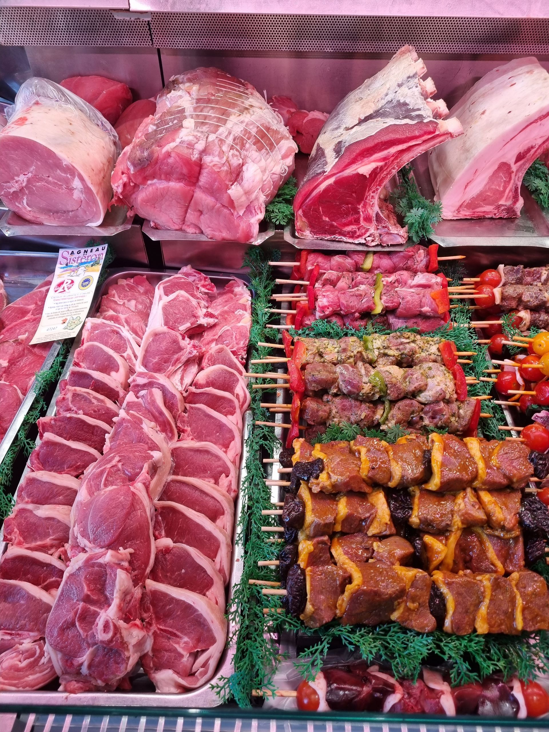 Photo d'un étal avec des morceaux de viandes et des brochettes