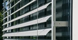 Immeuble de bureaux moderne en verre avec poutres horizontales blanches et auvents inclinés