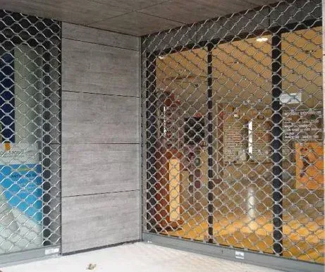 Façade de magasin fermée derrière des grilles de sécurité métalliques dans un couloir de centre commercial