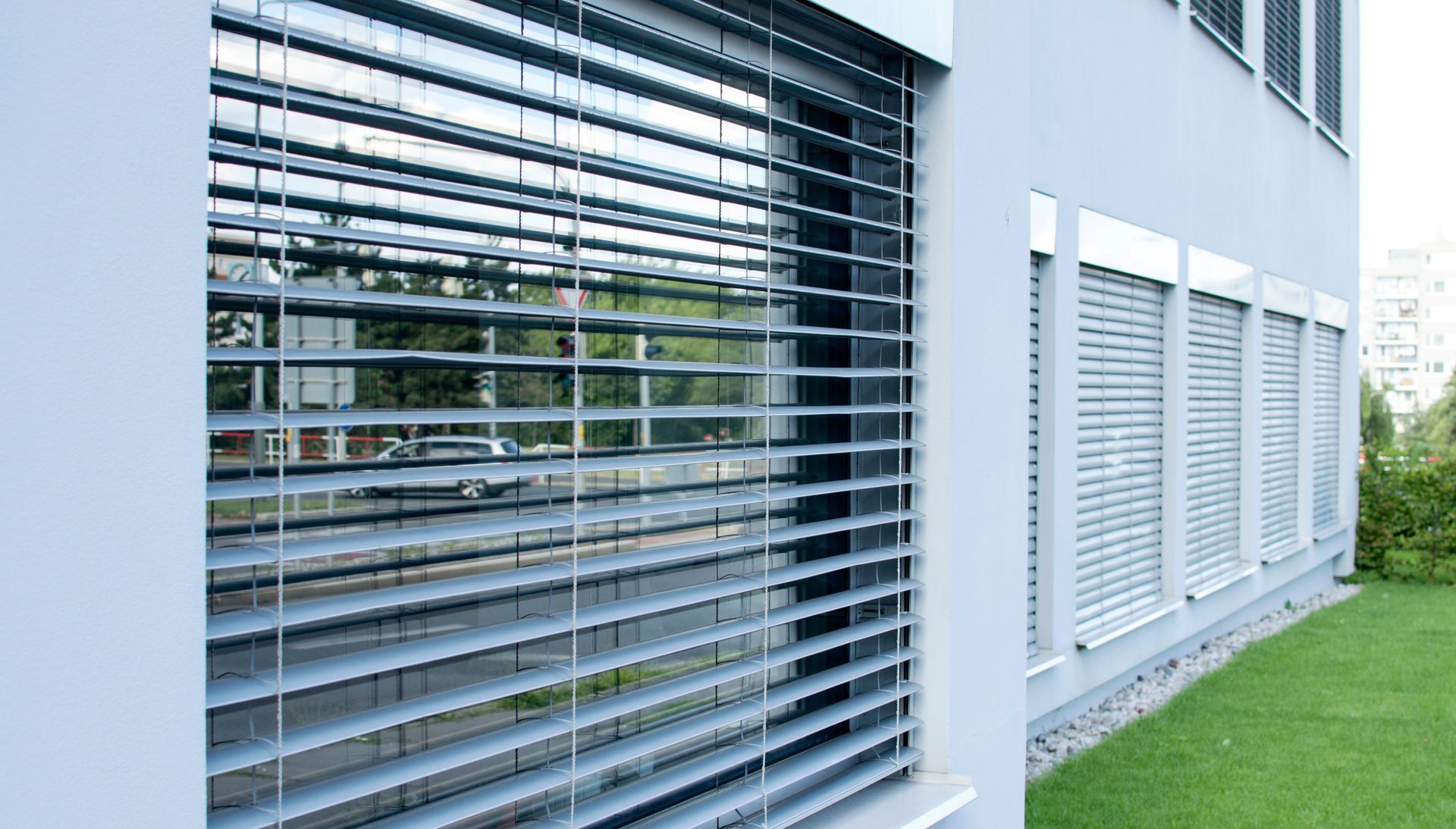 Extérieur de maison moderne avec trois volets persiennes blancs et une terrasse en bois