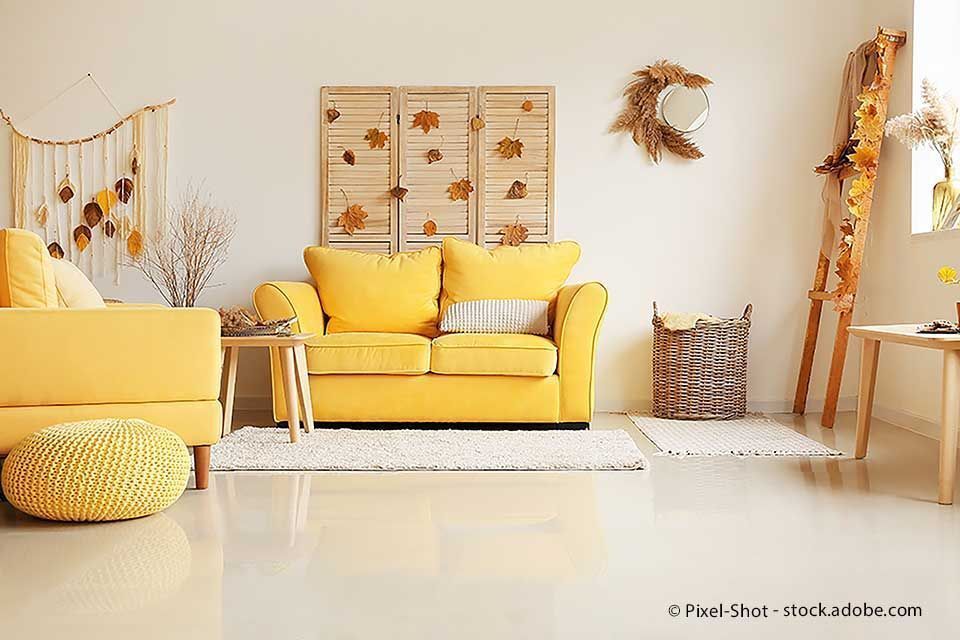 Gelbes Sofa und passendes Dekor in einem lichtdurchfluteten Raum.