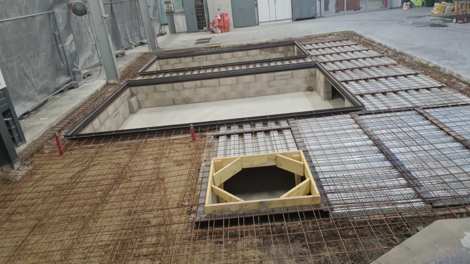 Chantier de construction avec treillis d'armature en acier et coffrage en bois