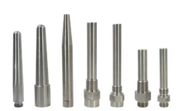 Sieben silberfarbene Metalldüsen in unterschiedlichen Formen und Größen in einer Reihe angeordnet, wahrscheinlich für den industriellen oder technischen Gebrauch.