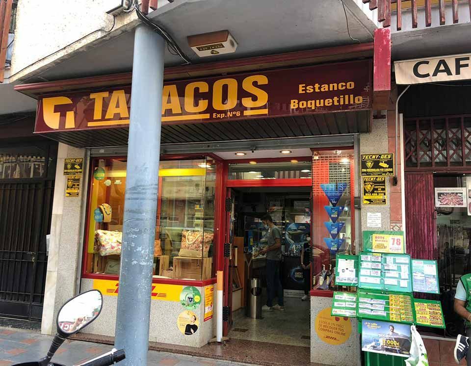 Una motocicleta está estacionada frente a una tienda llamada tabacos