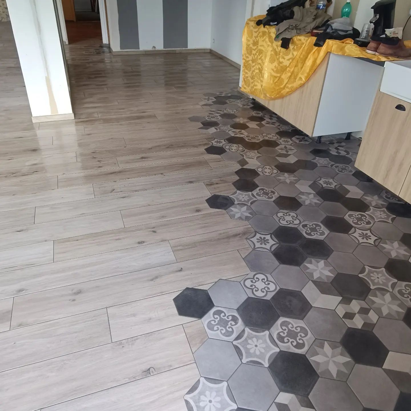 Pose d'un carrelage en forme d'hexagones noirs et gris