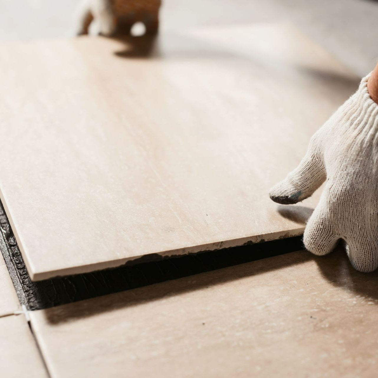 Un carreleur en train de poser du carrelage