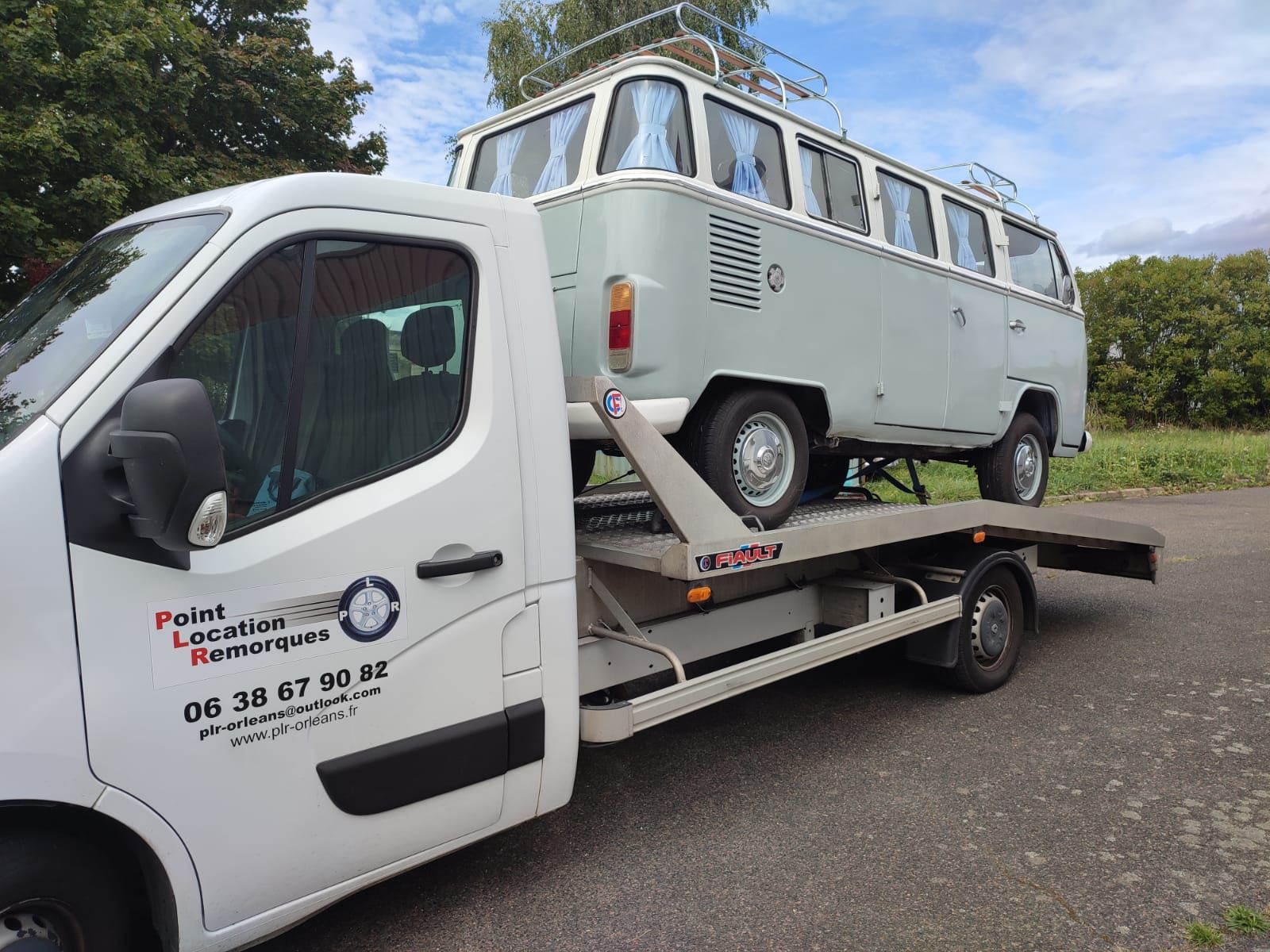 Un combi Volkswagen bleu clair sur une dépanneuse blanche.