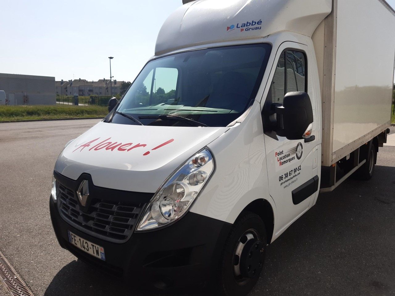 Un camion Renault blanc garé à l'extérieur.