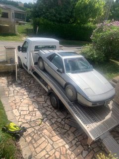 Une voiture de sport argentée est transportée par une dépanneuse.
