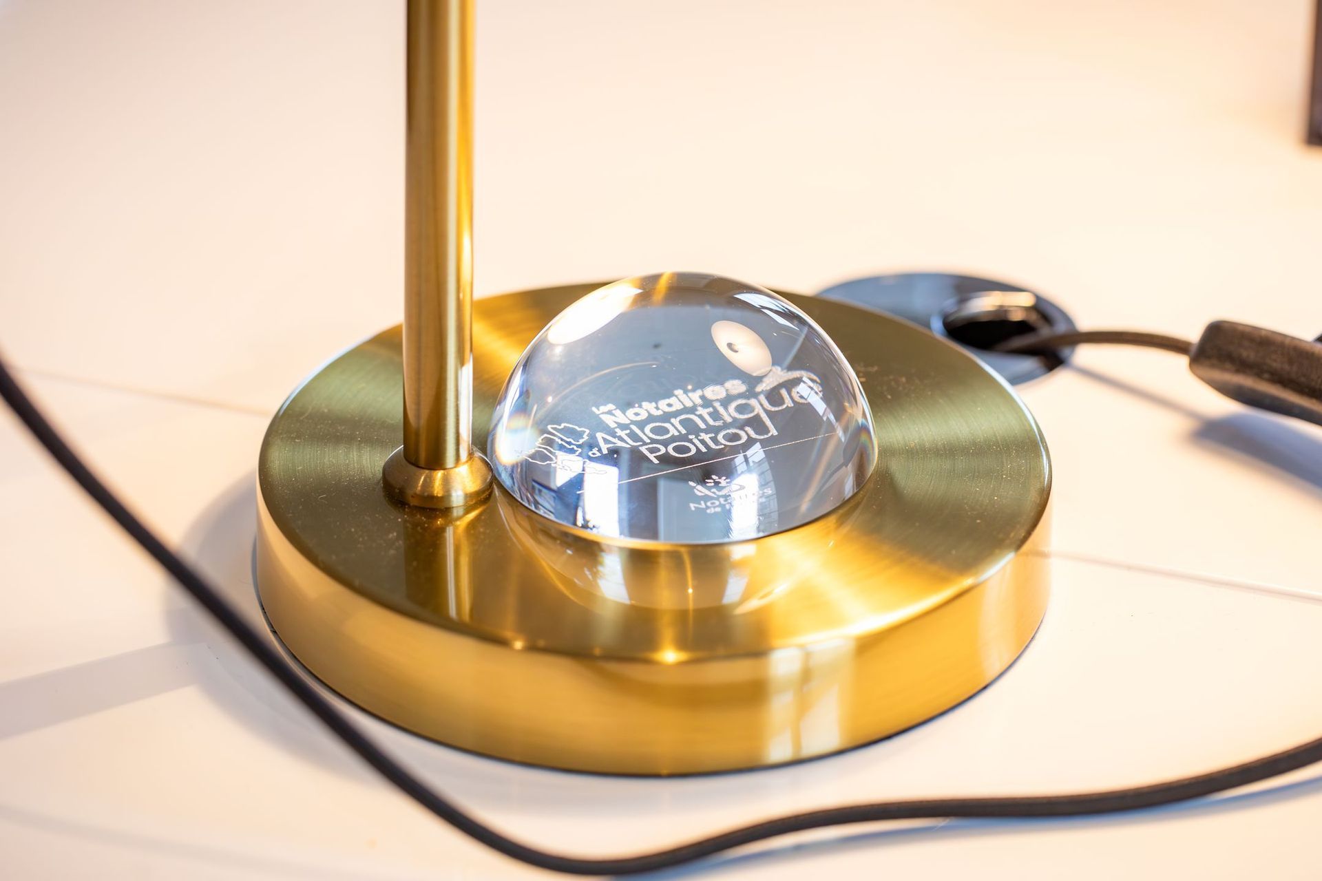 Un immeuble à plusieurs étages, avec une façade commerciale en verre à cadre sombre au rez-de-chaussée et un balcon.