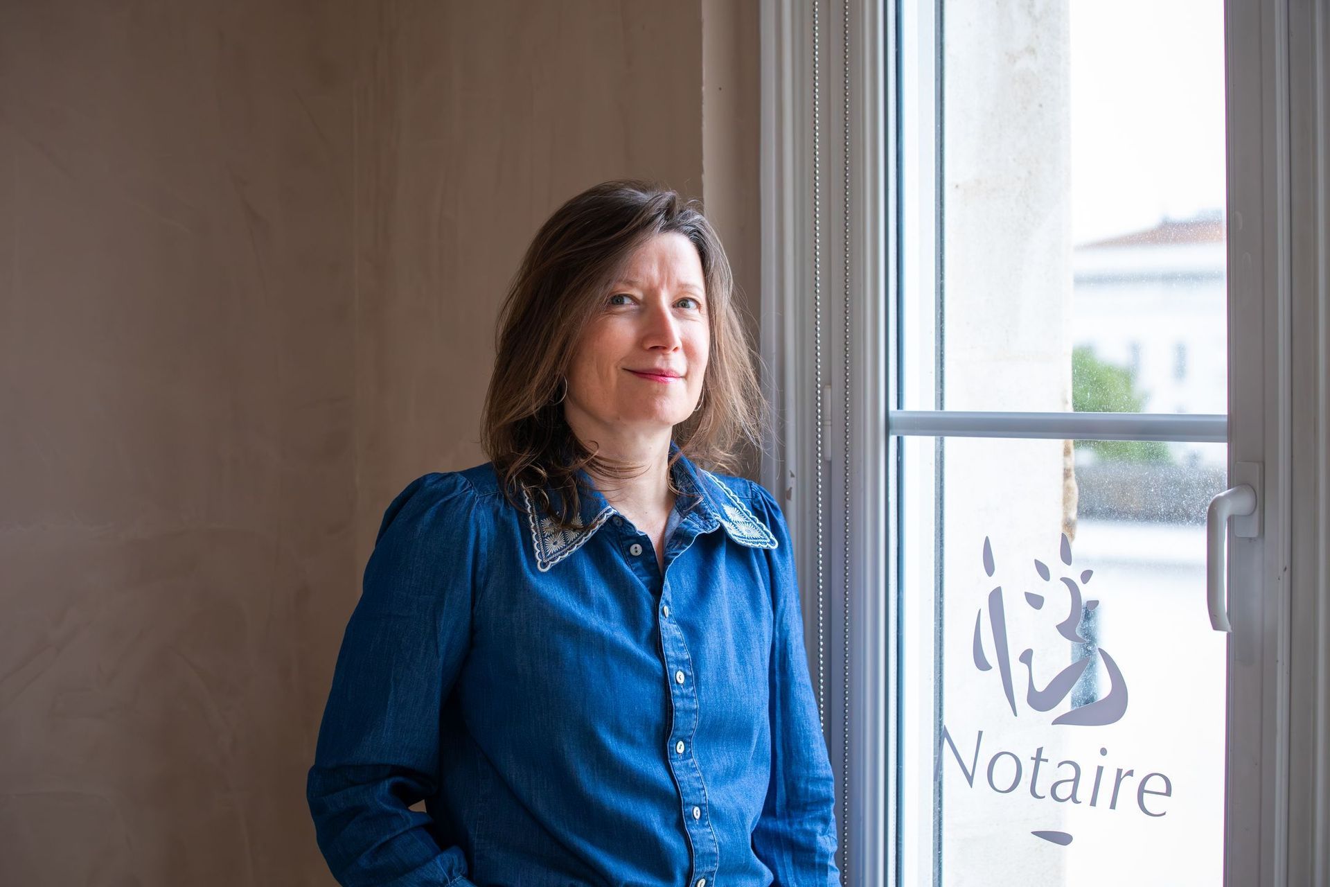 Deux chaises aux pieds dorés sont disposées sur un parquet clair près d'un bureau moderne.