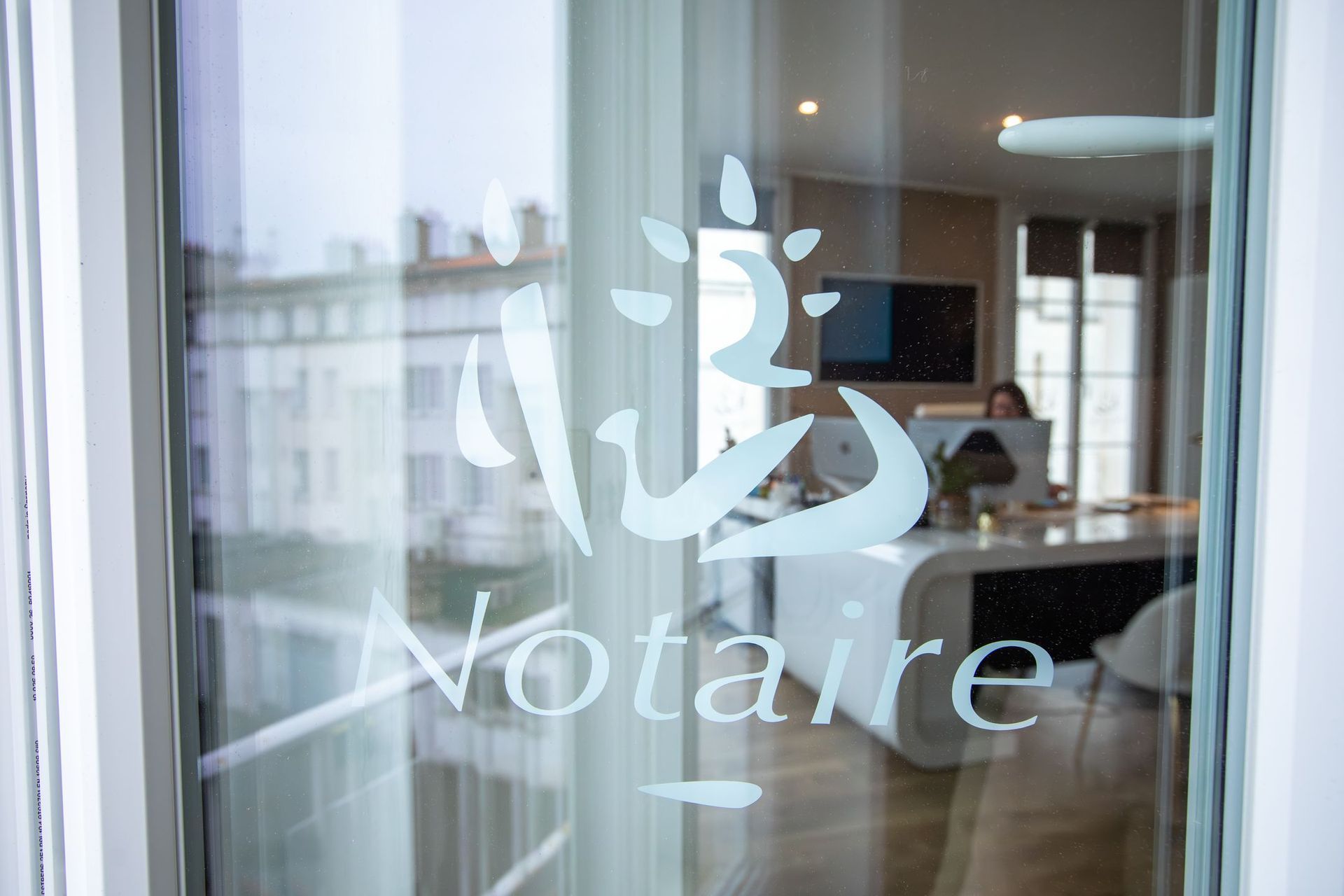 Des professionnels en costume sont assis à un bureau en bois, l'un d'eux désignant un document lors d'une consultation juridique.