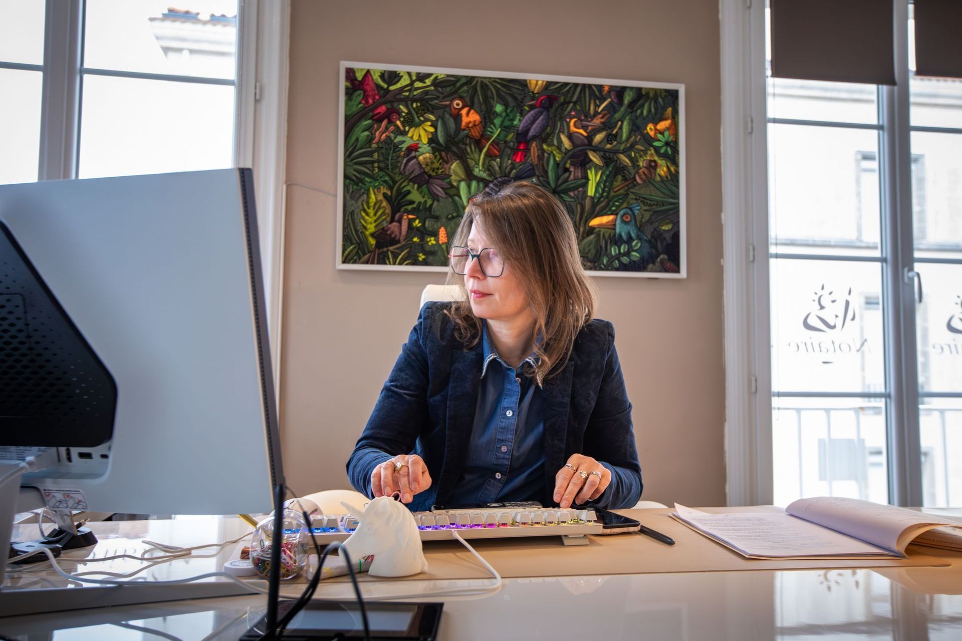 Une personne portant un haut rayé à manches longues écrit sur une feuille de papier posée sur une table en bois.