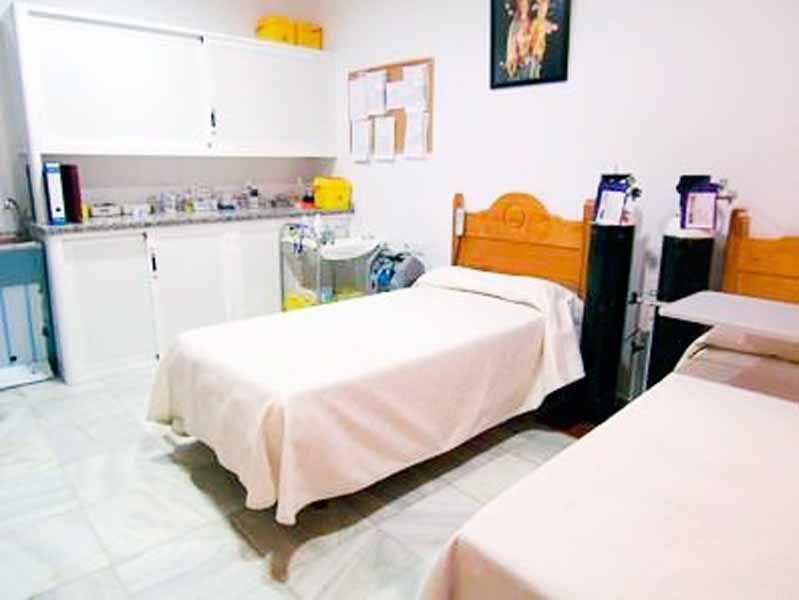 Una habitación con dos camas y un lavabo.