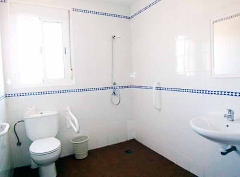 Un baño con inodoro, lavabo y ducha.