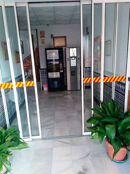 Un pasillo con puertas corredizas de vidrio y plantas en macetas.