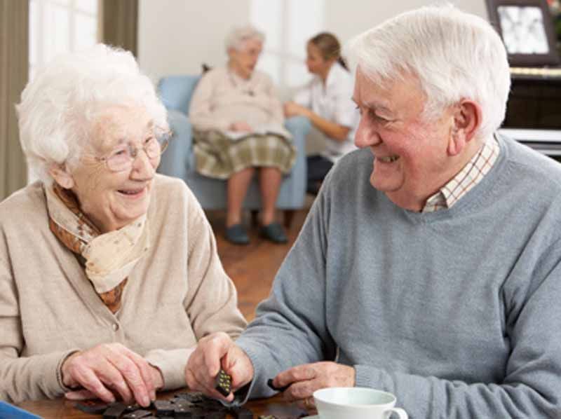 Un hombre y una mujer están sentados en una mesa jugando un juego.