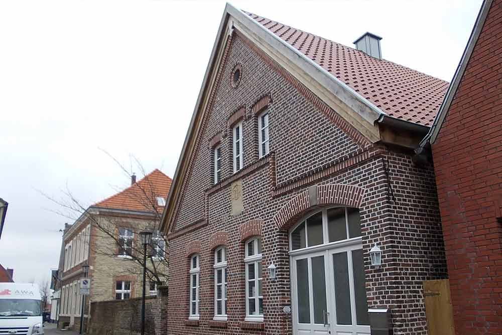 Ein weißer Lieferwagen steht vor einem Backsteingebäude