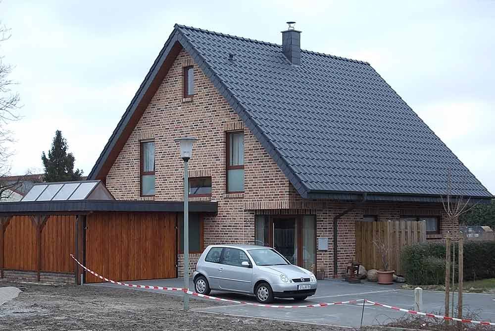 Ein Auto ist vor einem Backsteinhaus geparkt