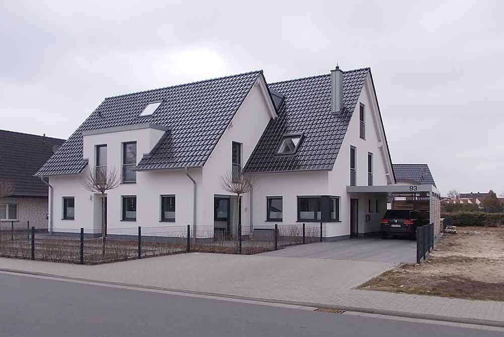 Ein weißes Haus mit einem davor geparkten Auto