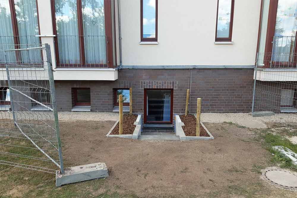 Ein Haus mit einem Zaun darum und einem Blumenkasten davor.