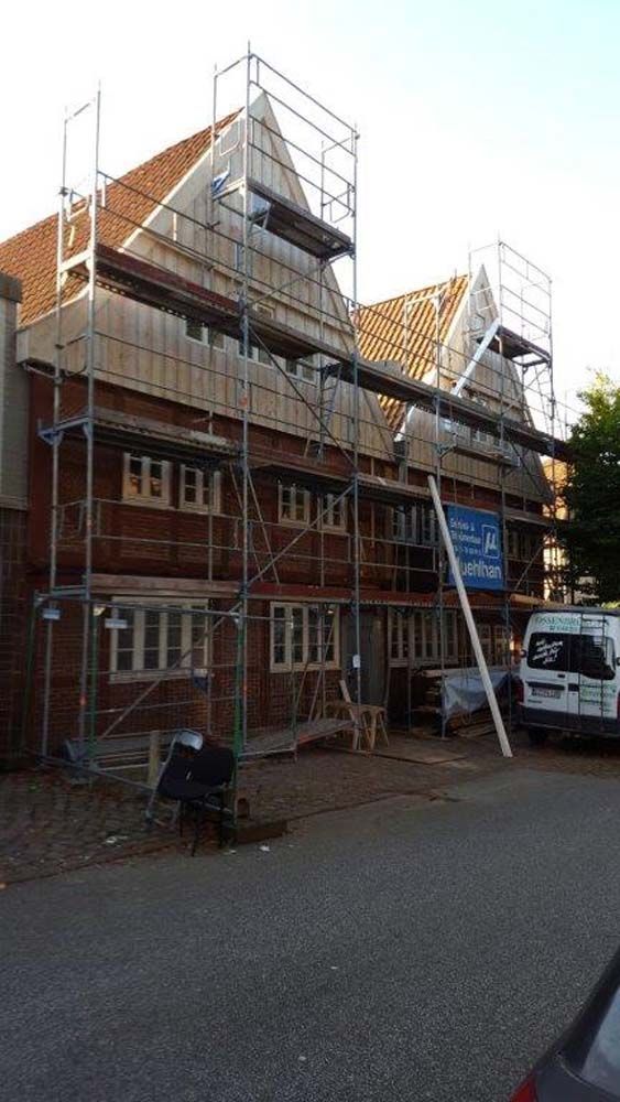 Gebäudefassade mit Gerüst, Ziegelfassade, in Renovierung.