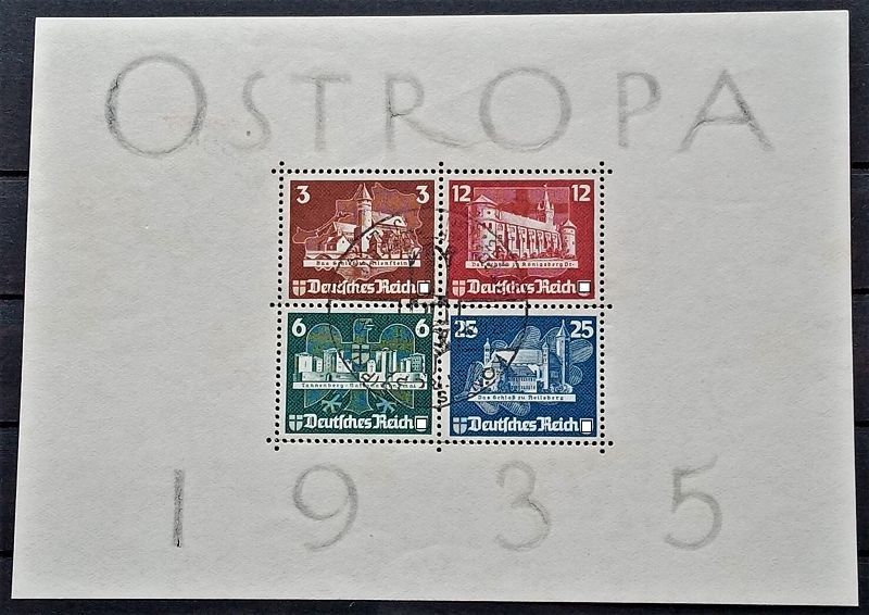 Vier deutsche Briefmarken (1935) auf cremefarbenem Papier, mit der Aufschrift „OSTROPA“ und „1935“ in grauem Bleistift.