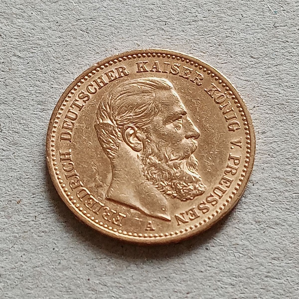 Goldmünze mit dem Profil eines bärtigen Mannes; der Text lautet: