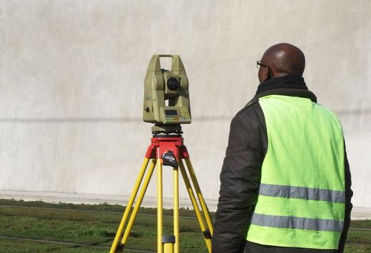 Un homme face à une caméra de topographe.
