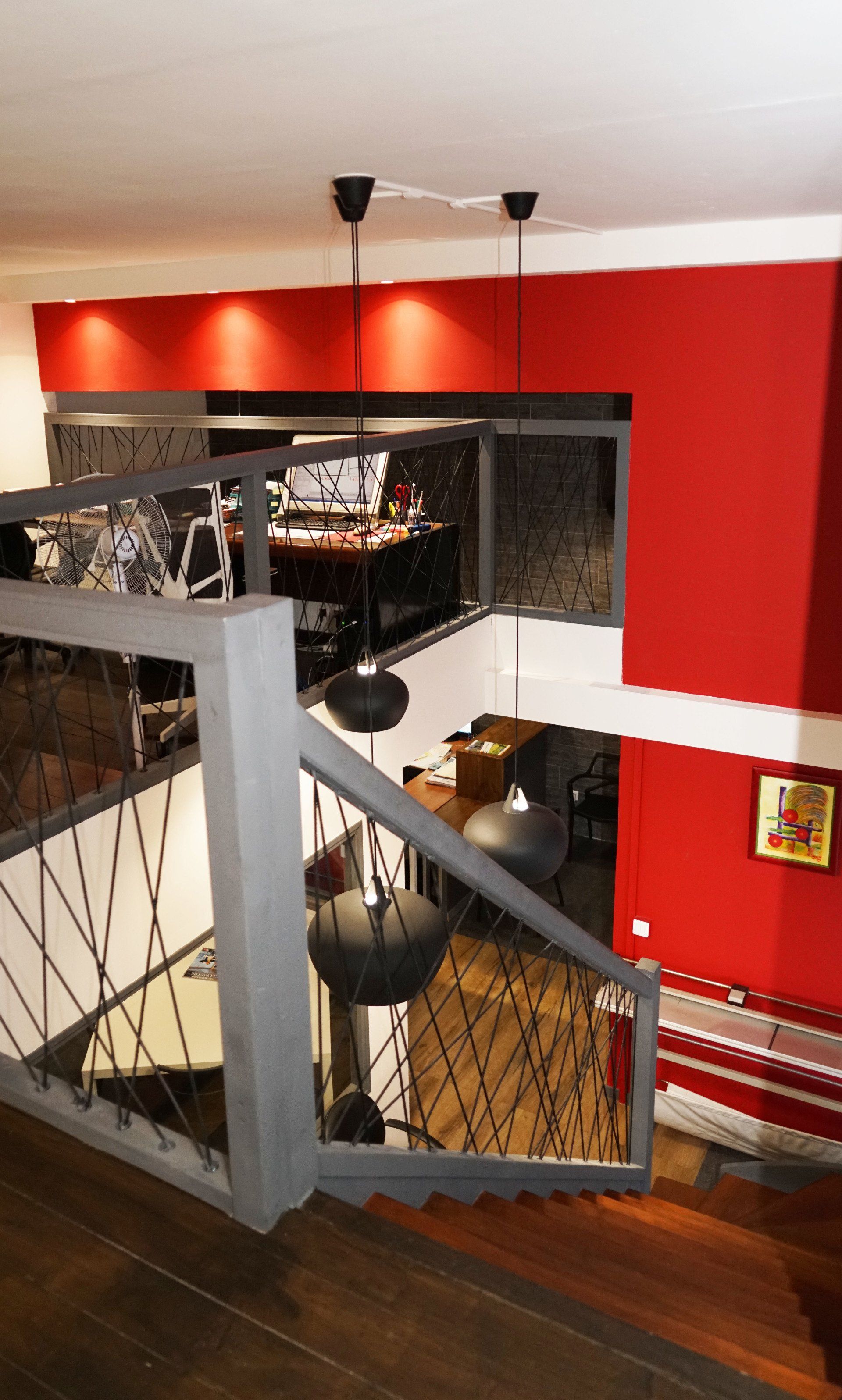 Une pièce rouge vue du haut des escaliers.