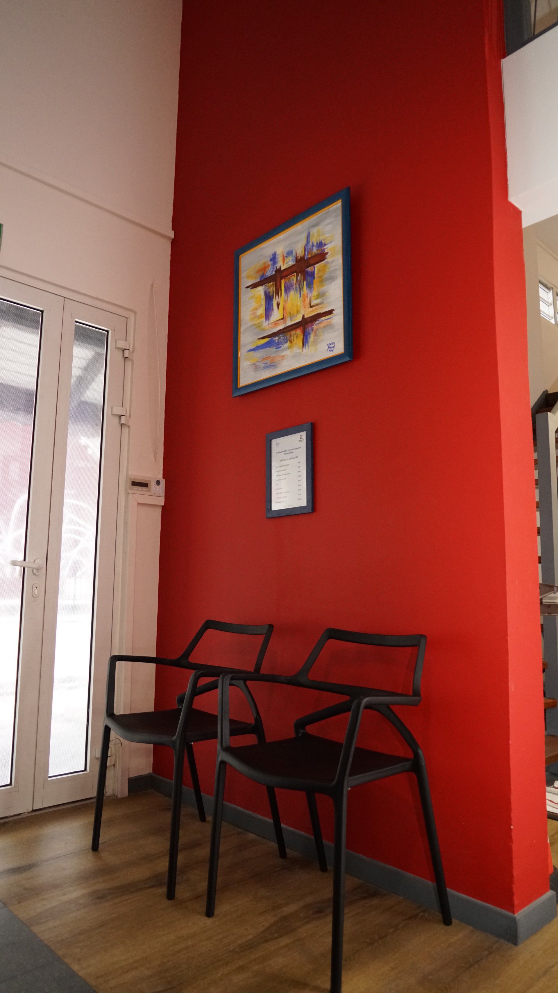 Une salle d'attente avec un mur rouge.