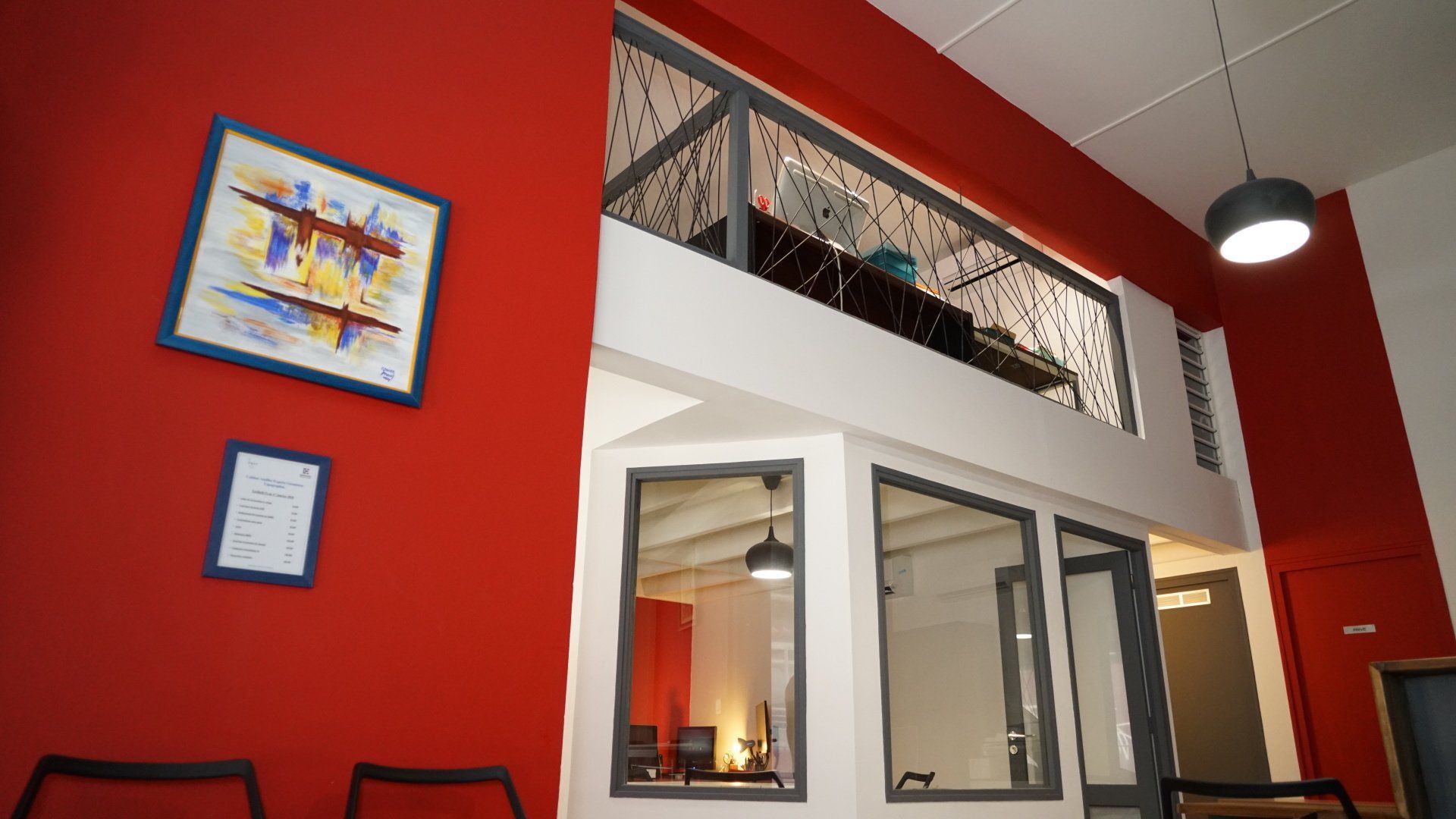 Une pièce rouge avec des grandes fenêtres.