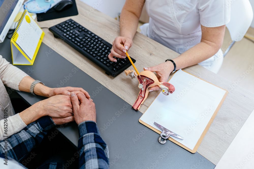 Un medico è seduto alla scrivania e parla con un paziente tenendogli le mani