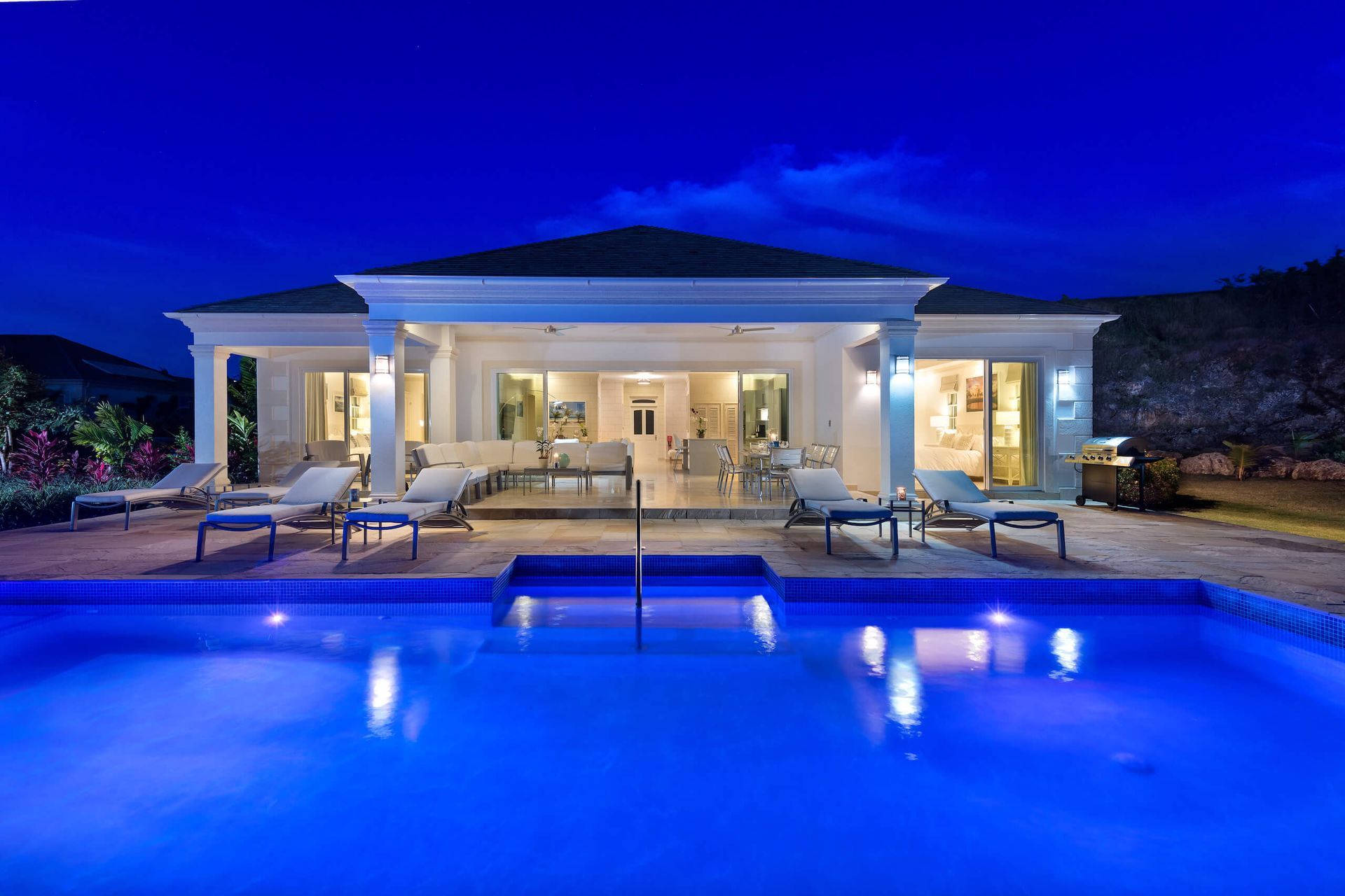 a large house with a swimming pool in front of it at night