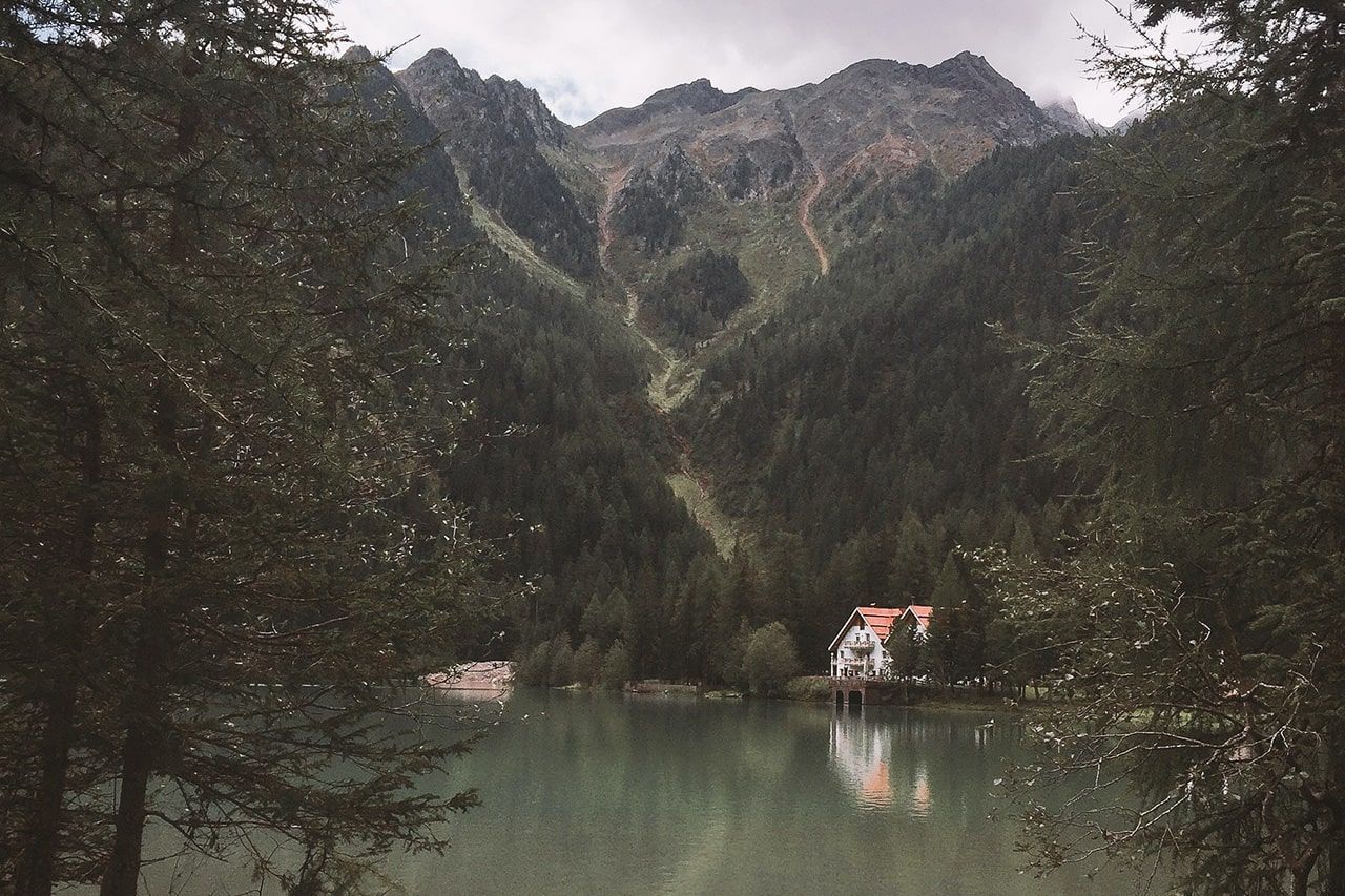 a lake surrounded by trees with mountains in the background