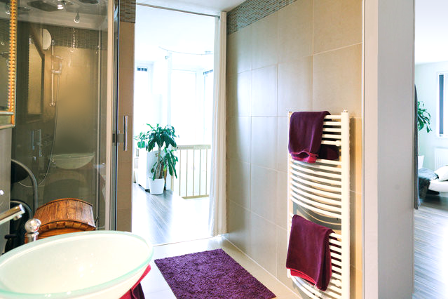 a bathroom with a sink , towel rack , and purple rug