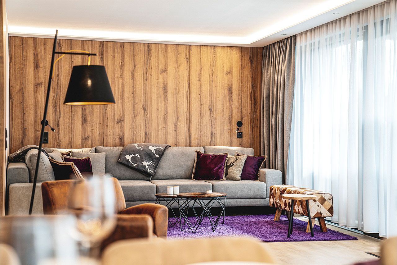 a living room with a couch , chairs , a table and a lamp