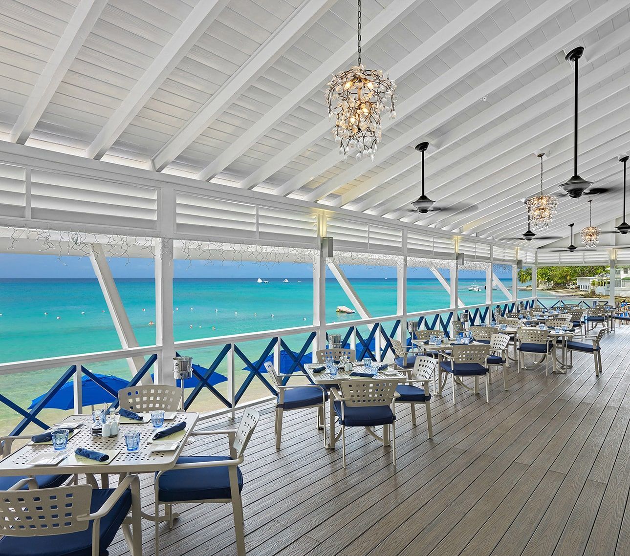 a restaurant with tables and chairs overlooking the ocean
