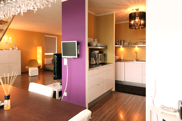 a kitchen with purple walls and white cabinets