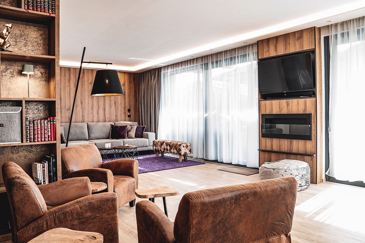 a living room with a couch , chairs , tables and a television