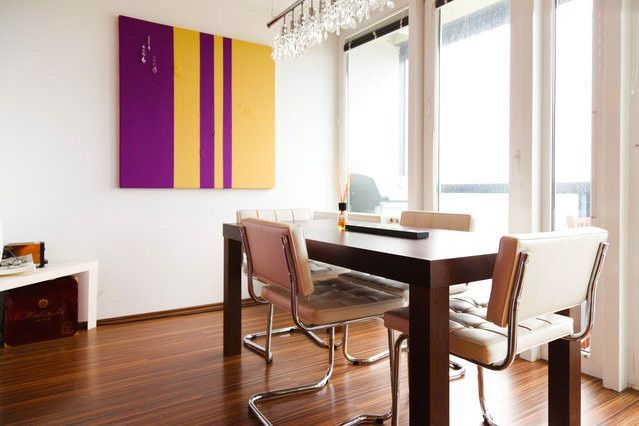 a dining room with a table and chairs and a painting on the wall
