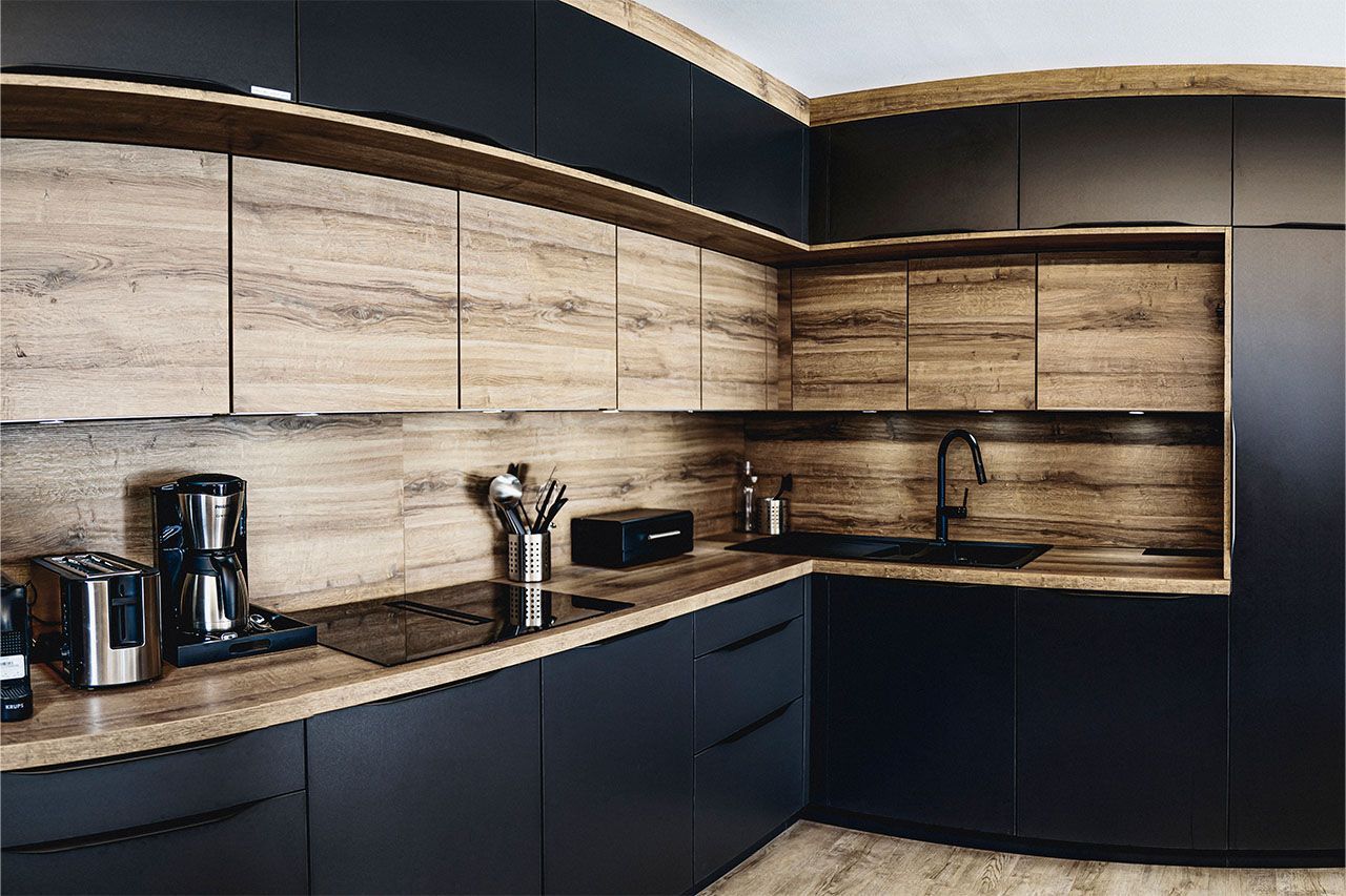 a kitchen with black cabinets and wooden counter tops