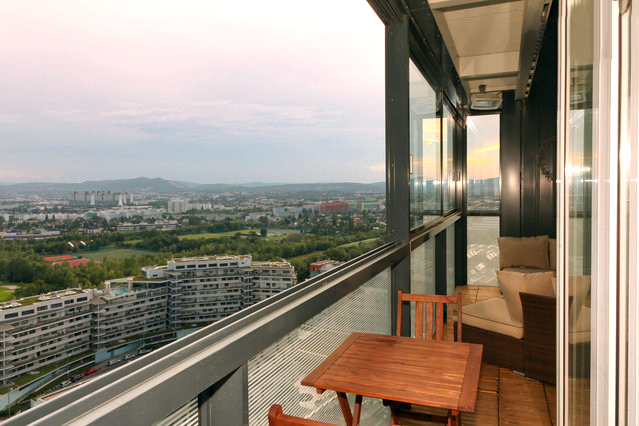 a balcony with a table and chairs overlooking a city
