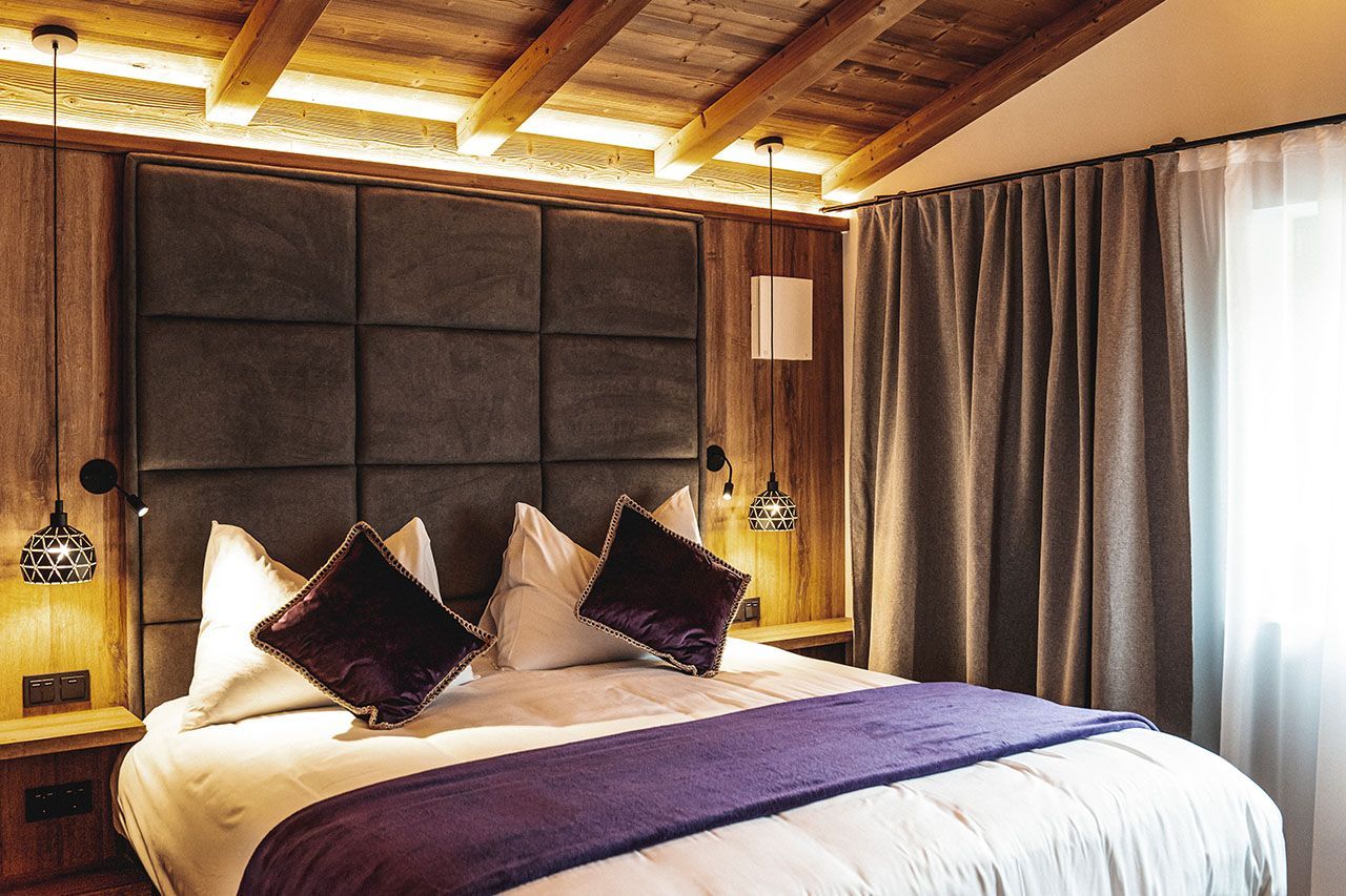 a hotel room with a king size bed and purple pillows