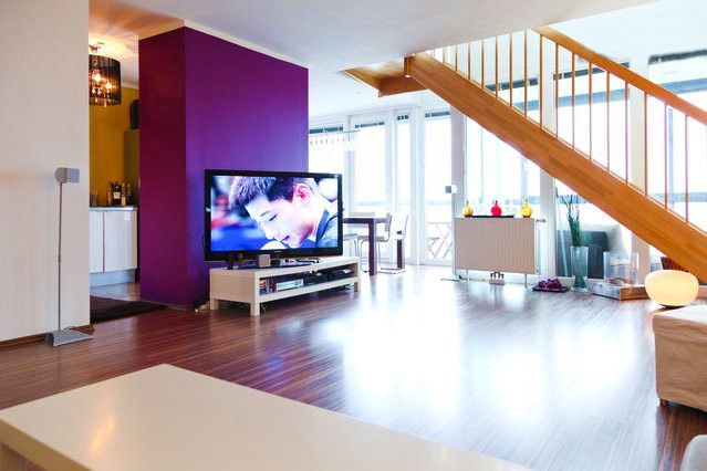 a living room with a purple wall and a flat screen tv