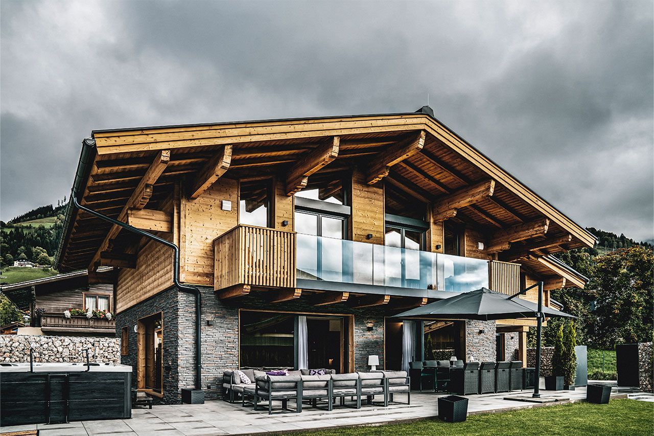 a large wooden house with a hot tub in front of it .