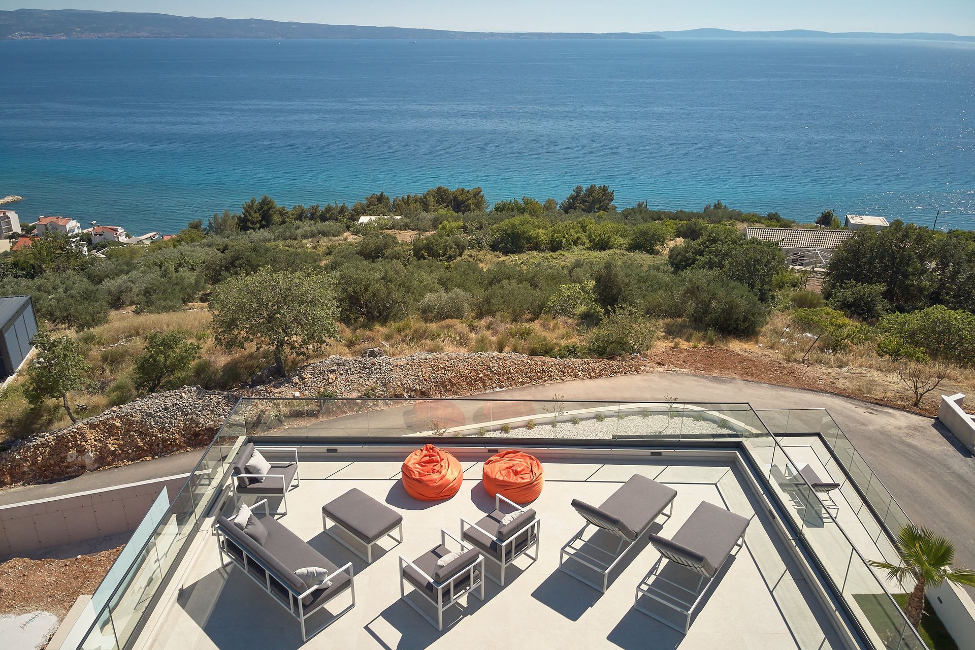 an aerial view of a patio with chairs and tables overlooking the ocean .