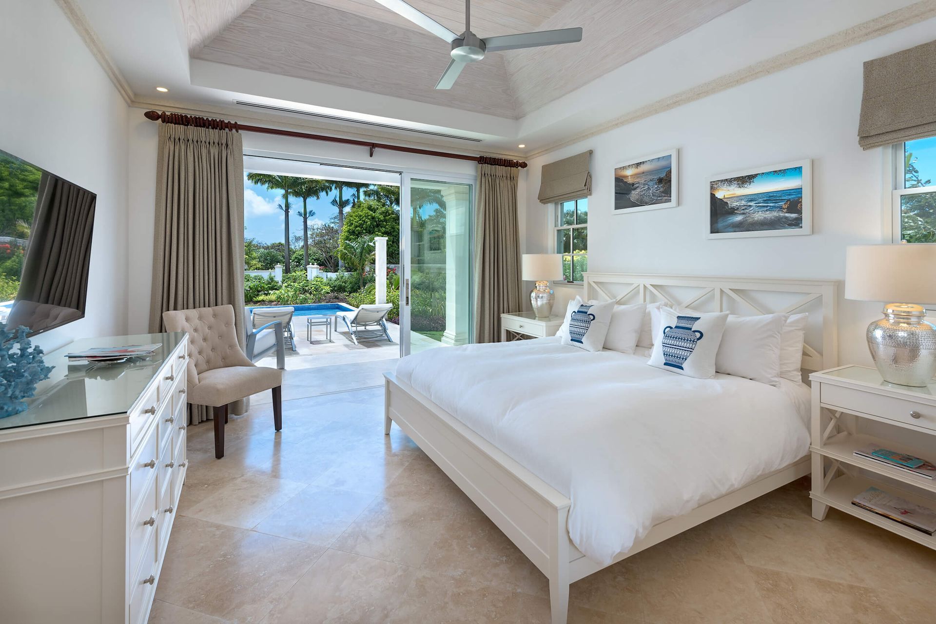 a bedroom with a king size bed , dresser , chair and television .