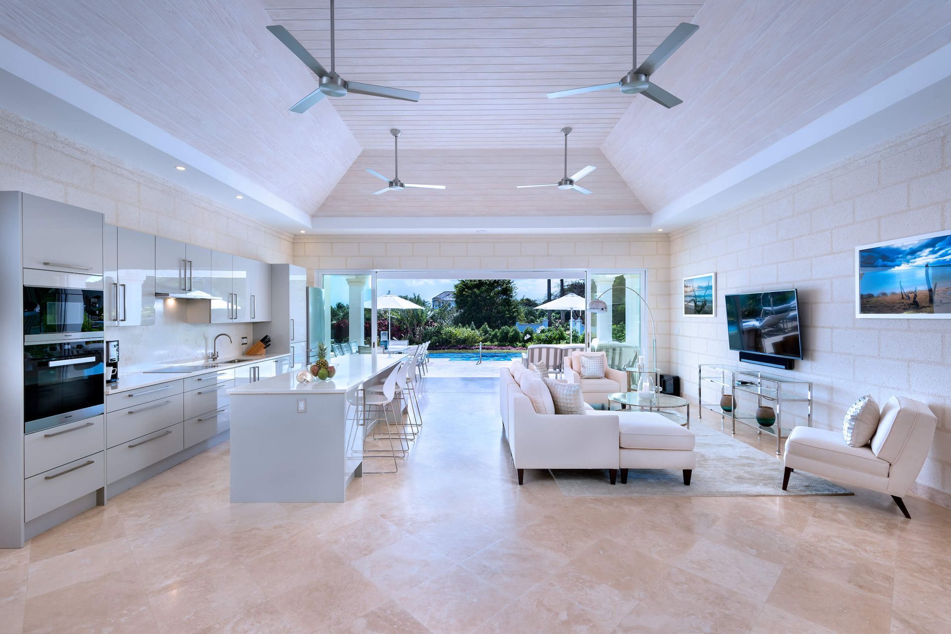 a living room with a couch , chairs , and a ceiling fan .
